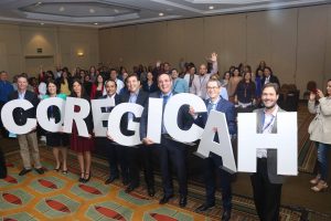 Grupo de participantes de COREGICAH posa con el nombre del congreso